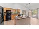 Well-lit kitchen boasting an island, modern appliances, and sliding doors to the backyard at 11405 W Windsor Ave, Avondale, AZ 85392
