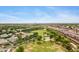 Expansive aerial view of community featuring green spaces, highway, and a park with a basketball court at 1316 S Minneola Ln, Gilbert, AZ 85296