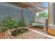 Charming backyard with a cozy daybed, shade sail, and a decorative pond with rocks and flowers at 1316 S Minneola Ln, Gilbert, AZ 85296
