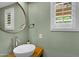 Stylish powder room features a modern sink, a round mirror and natural light from the window at 1316 S Minneola Ln, Gilbert, AZ 85296