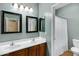 Bathroom with double vanity, framed mirrors, tile floors, and a shower behind a curtain at 1316 S Minneola Ln, Gilbert, AZ 85296