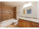 Bathroom with granite counters, wood cabinets, decorative tile and shower-tub combination at 1320 E Butler Dr, Phoenix, AZ 85020