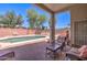 Backyard oasis with a sparkling swimming pool, brick patio, and comfortable outdoor seating at 14298 W Amelia Ave, Goodyear, AZ 85395