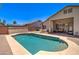 Delight in this backyard featuring a private pool, covered patio, and lush landscaping, ideal for outdoor gatherings and relaxation at 14298 W Amelia Ave, Goodyear, AZ 85395