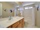 Bathroom featuring a vanity with generous counter space and a shower-tub combo at 14298 W Amelia Ave, Goodyear, AZ 85395