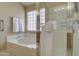 Close-up view of soaking tub and glass enclosed walk-in shower at 14298 W Amelia Ave, Goodyear, AZ 85395