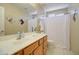 Bathroom featuring a vanity with generous counter space and a shower-tub combo at 14298 W Amelia Ave, Goodyear, AZ 85395