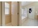 Bright bathroom features a walk-in shower, soaking tub, and tile flooring at 14298 W Amelia Ave, Goodyear, AZ 85395