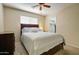 Bedroom features a comfortable bed, ceiling fan, natural lighting, and a walk in closet at 14298 W Amelia Ave, Goodyear, AZ 85395