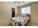 Cozy bedroom with a ceiling fan, window with blinds, and floral bedspread at 14298 W Amelia Ave, Goodyear, AZ 85395