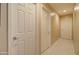 Bright hallway featuring multiple white doors and neutral tiling at 14298 W Amelia Ave, Goodyear, AZ 85395