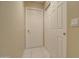 Neutral hallway features white doors, tile flooring, and beige walls at 14298 W Amelia Ave, Goodyear, AZ 85395