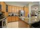 Well-equipped kitchen with granite countertops, wooden cabinets, and modern stainless steel appliances at 14298 W Amelia Ave, Goodyear, AZ 85395