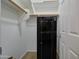 This walk-in closet features multiple shelves, a wooden rail, and a black Stack-On safe at 14298 W Amelia Ave, Goodyear, AZ 85395