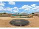 Spacious backyard with in-ground trampoline and sparkling pool with fun water slide at 16938 N Verde Pl, Maricopa, AZ 85138