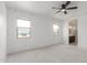 Bedroom with a ceiling fan, two windows, and a view into the bathroom at 16938 N Verde Pl, Maricopa, AZ 85138