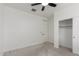 A bright bedroom featuring neutral carpet, ceiling fan, closet and white walls at 16938 N Verde Pl, Maricopa, AZ 85138