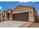 Single-story home featuring a two-car garage, brick-lined walkway and neutral stucco at 16938 N Verde Pl, Maricopa, AZ 85138