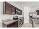 Kitchen features stainless steel appliances, granite countertops, and wooden cabinets at 16938 N Verde Pl, Maricopa, AZ 85138