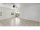 Bright living room featuring neutral tile flooring, a ceiling fan and sliding glass doors at 16938 N Verde Pl, Maricopa, AZ 85138