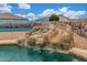 Backyard pool with a custom rock slide and desert landscaping, perfect for entertaining at 16938 N Verde Pl, Maricopa, AZ 85138