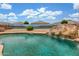Backyard pool featuring a rock waterfall and slide creating the ultimate retreat at 16938 N Verde Pl, Maricopa, AZ 85138