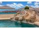 Backyard pool with a custom rock slide and desert landscaping, perfect for entertaining at 16938 N Verde Pl, Maricopa, AZ 85138