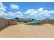Backyard pool with desert landscaping and a blue umbrella, perfect for relaxing and entertaining at 16938 N Verde Pl, Maricopa, AZ 85138