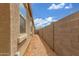 Side yard showcasing low-maintenance desert landscaping and block wall at 16938 N Verde Pl, Maricopa, AZ 85138