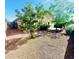 Large private backyard featuring mature trees and gravel landscaping provides a serene retreat at 18166 W Camino Real Dr, Surprise, AZ 85374