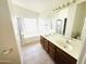 Bright bathroom with dual sinks, a bathtub, and a separate shower at 18166 W Camino Real Dr, Surprise, AZ 85374