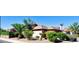 Desert home with a tiled roof and lush landscaping including palm trees at 18166 W Camino Real Dr, Surprise, AZ 85374