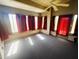 Bright sunroom with lots of windows, red curtains, and carpet flooring provides a relaxing space at 18166 W Camino Real Dr, Surprise, AZ 85374