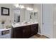 Stylish bathroom with double vanity, quartz countertop, dark cabinets, and large mirror at 18366 N Arbor Dr, Maricopa, AZ 85138