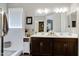 Well-lit bathroom with double vanity, dark cabinets, and a large mirror at 18366 N Arbor Dr, Maricopa, AZ 85138
