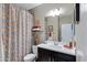 Well-maintained bathroom featuring a modern vanity, colorful shower curtain, and bright lighting at 18366 N Arbor Dr, Maricopa, AZ 85138