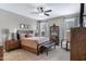 Comfortable bedroom featuring a ceiling fan, bench seat, and natural light from two sunny windows at 18366 N Arbor Dr, Maricopa, AZ 85138
