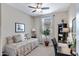 Bedroom featuring a daybed, desk, ceiling fan, and a large window at 18366 N Arbor Dr, Maricopa, AZ 85138