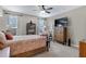 Relaxing bedroom with a large TV, dresser, ceiling fan and natural light from the bright windows at 18366 N Arbor Dr, Maricopa, AZ 85138