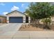 Inviting single-story home featuring a desert landscape, a blue garage door, and a covered porch at 18366 N Arbor Dr, Maricopa, AZ 85138