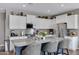 Modern kitchen with stainless steel appliances, granite countertops, white cabinets, and kitchen island with barstool seating at 18366 N Arbor Dr, Maricopa, AZ 85138