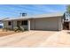 Single-story home with attached two-car garage, a long driveway, and minimal landscaping at 18427 N 32Nd Ln, Phoenix, AZ 85053