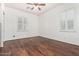 Bedroom with hardwood floors, a ceiling fan, and windows with plantation shutters at 30135 N 129Th Gln, Peoria, AZ 85383