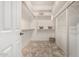 Walk-in closet featuring shelving, closet rods, and tile flooring for organized storage at 30135 N 129Th Gln, Peoria, AZ 85383