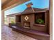 Outdoor fireplace with a bench offers a cozy spot for relaxation and entertaining at 30135 N 129Th Gln, Peoria, AZ 85383