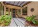Welcoming covered front porch featuring stone accents, lush landscaping, and plenty of natural light at 30135 N 129Th Gln, Peoria, AZ 85383