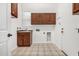 Well-lit laundry room with brown cabinets, tile floor, and utility sink offers practical space at 30135 N 129Th Gln, Peoria, AZ 85383