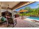 Inviting outdoor space with a built-in barbecue, fireplace, seating, and pool views at 30135 N 129Th Gln, Peoria, AZ 85383