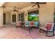Cozy covered patio with comfortable seating, ceiling fans, and views of lush landscaping at 30135 N 129Th Gln, Peoria, AZ 85383