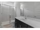 Modern bathroom featuring glass enclosed shower, bright white countertops, and dark cabinetry at 3260 W Caleb Rd, Phoenix, AZ 85083